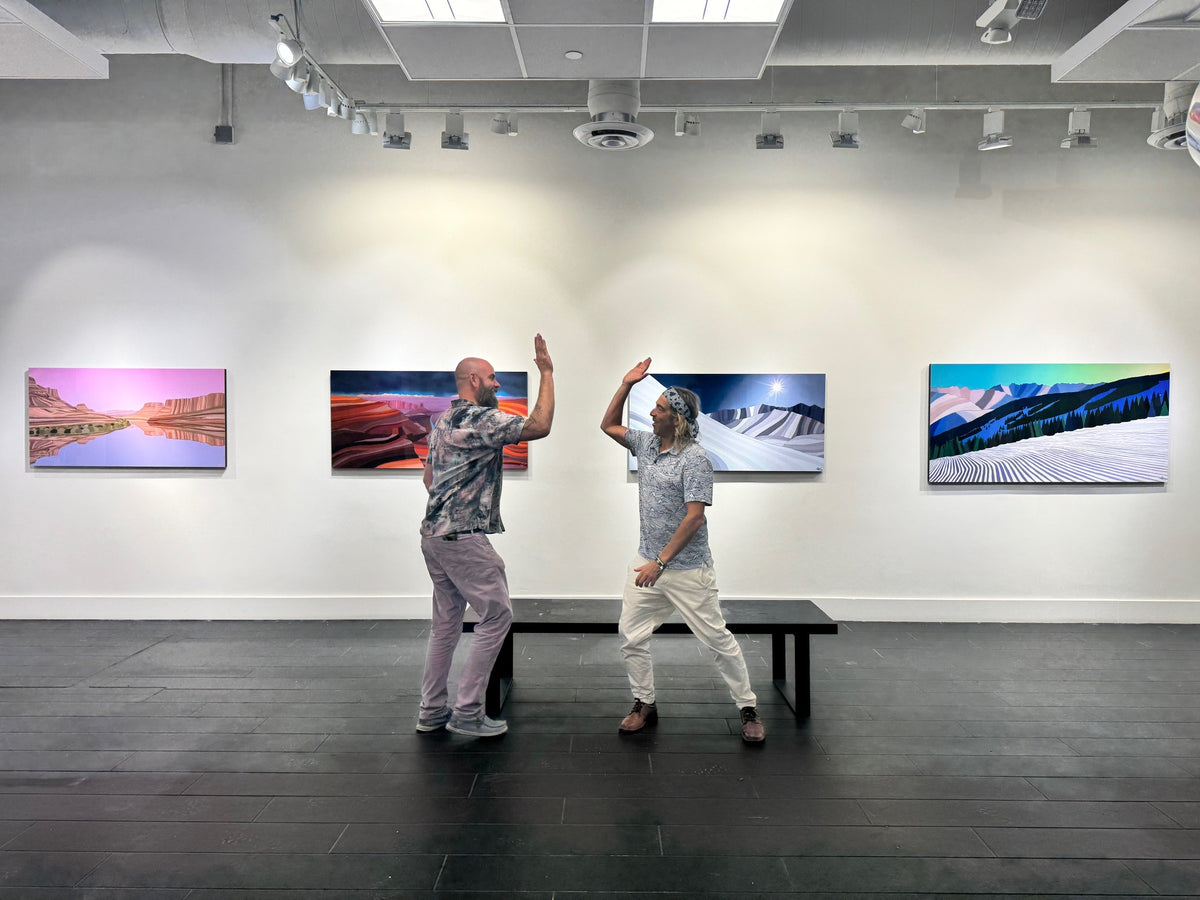 Topher Straus and Axiom Contemporary co-founder Jay Kirk high-fiving beneath Topher's paintings